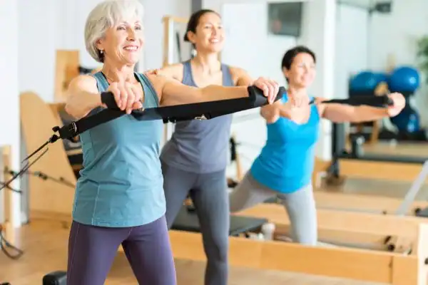 Toning Arms After 60: Empowering Womens Fitness Through Effective Weight Training 2 older woman doing weight training Wealdstone and resistance in the gym to tone upper arms
