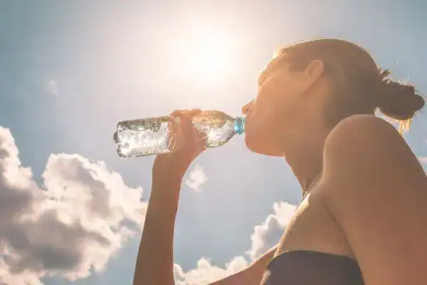 Hydration: The Secret Ingredient for a Toned Stomach and Enhanced Fitness 3 Image of woman drinking water to hydrate Wealdstone after run.