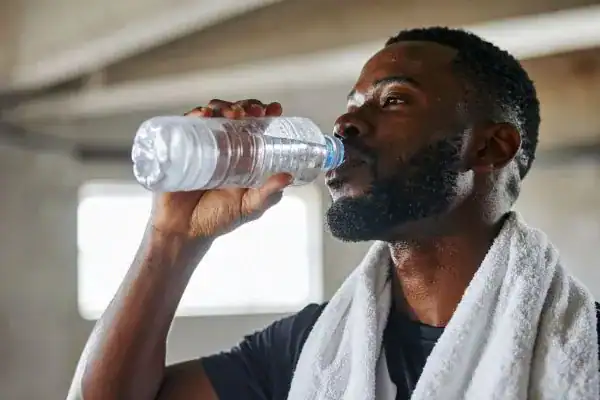 Hydration: The Secret Ingredient for a Toned Stomach and Enhanced Fitness 1 Image of man drinking water to improve hydration Wealdstone after work out.